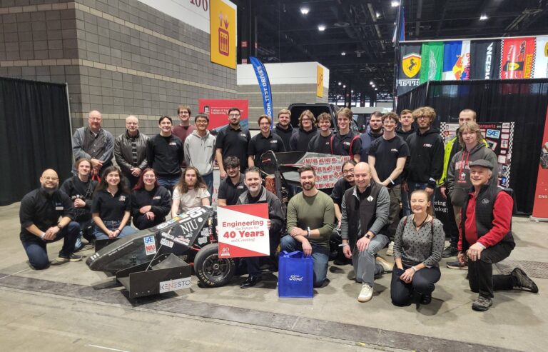 Members of NIU Huskie Motorsports and the Chicago section of the Society of Automotive Engineers (SAE) gather by the team’s booth.